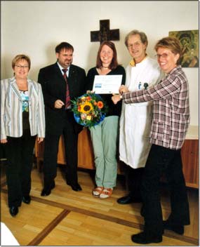 Freuen sich mit der Gewinnerin Anja Hitzler (Mitte): (v.l.) Rosemarie Schenk und Christian Schuster von der AOK, Chefarzt Dr. Helmut Boehm und stellvertretende Pflegedienstleitung Bettina Beyer-Lichtblau. © KJF/Ruess
